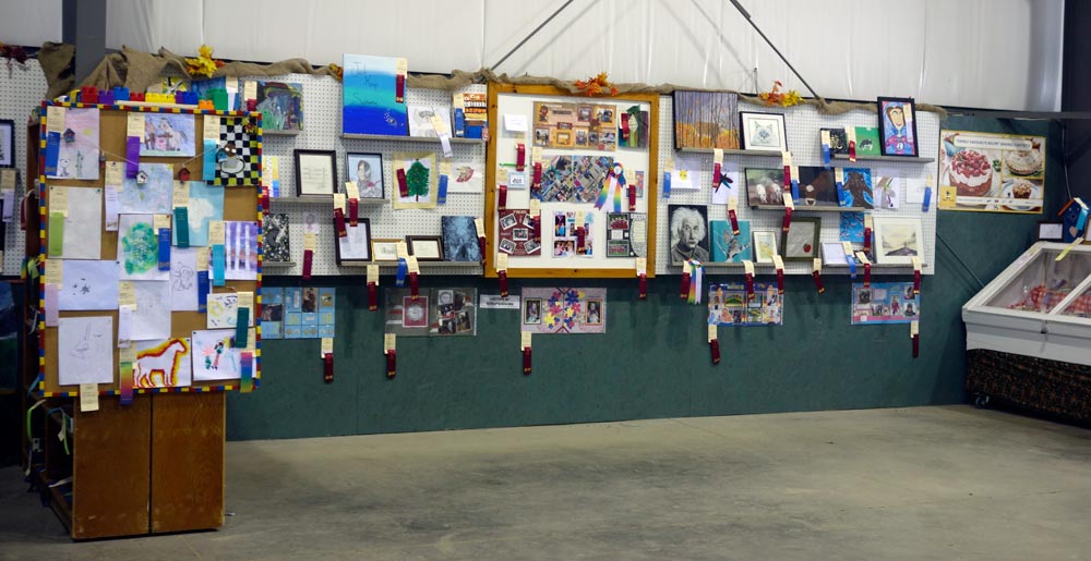 A wall full of painting and drawings.